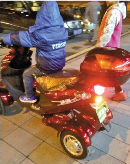 “土豪”小男孩正骑着电动车,旁边站着“女友”(网图) “土豪”小男孩正骑着电动车,旁边站着“女友”(网图)